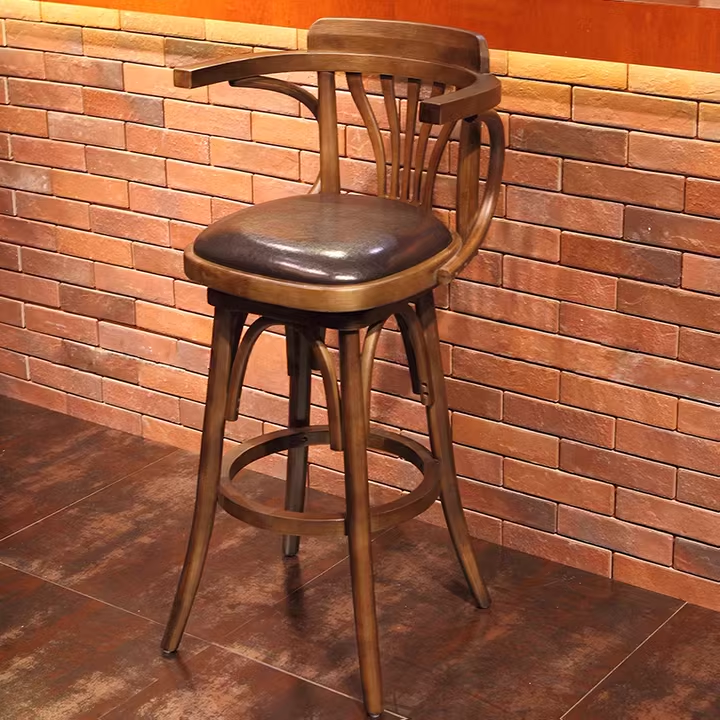 Wooden bar stool with curved backrest and leather seat. Ideal for restaurants or bars, durable wooden frame.