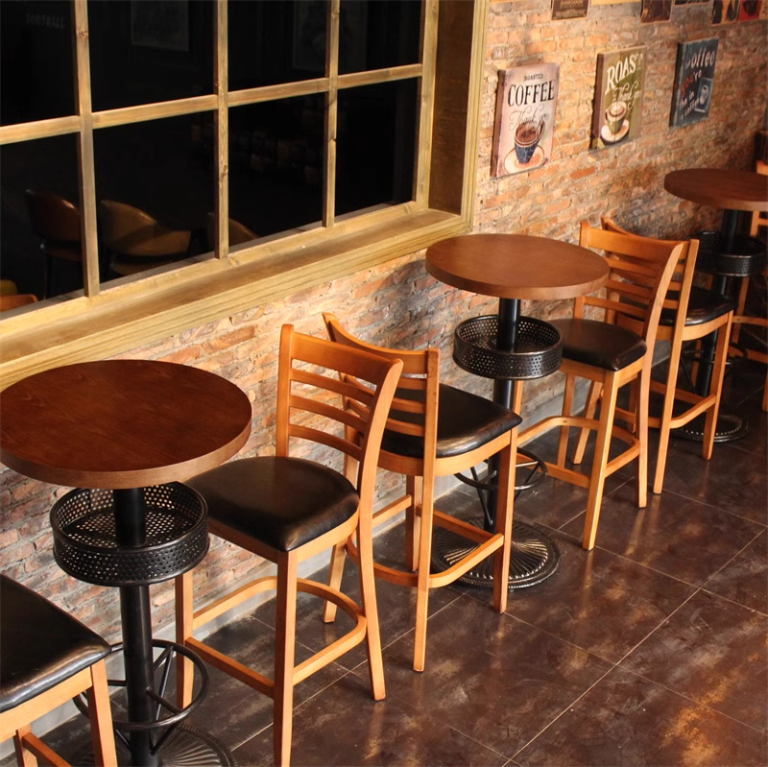 Wooden bar stool with black cushioned seat, featuring a ladder-back design, set in various restaurant and café environments.