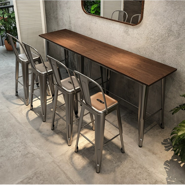 Metal stools around a wooden bar table with a minimalist aesthetic in a modern setting.