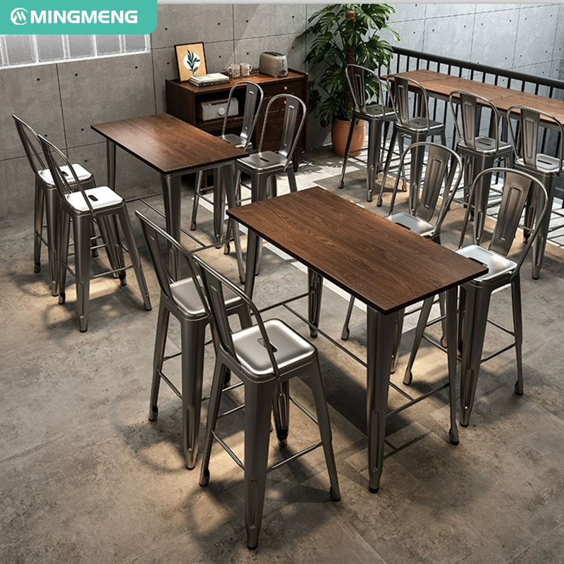 Metal stools around a wooden bar table with a minimalist aesthetic in a modern setting.