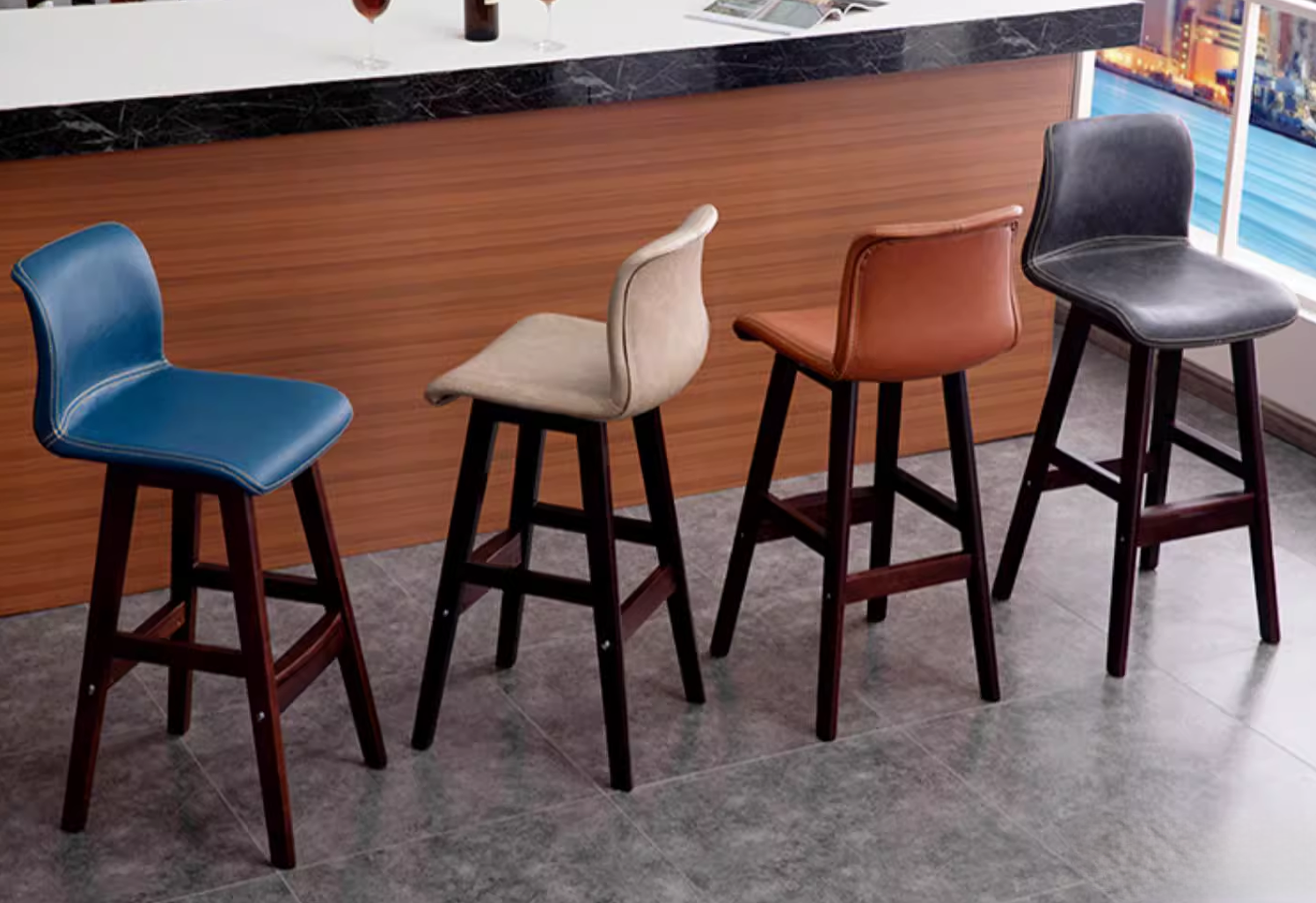 Set of modern bar stools with colorful leather seats and wooden legs, ideal for home bars and kitchens, offering a stylish and comfortable seating solution.