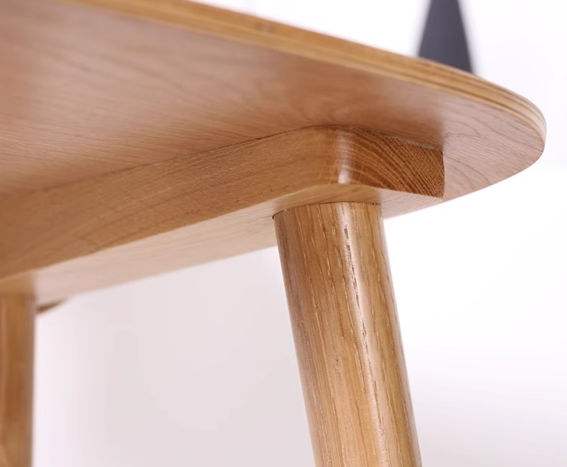 Close-up of oak wood chair backrest corner showing seamless craftsmanship and natural wood texture.