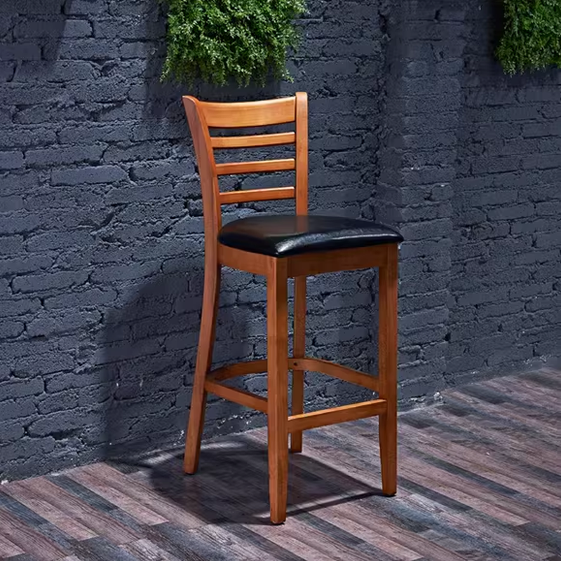 Industrial-style wooden bar stool with a black cushioned seat, set against a dark background, ideal for bars, casual restaurants, and vintage-themed spaces.