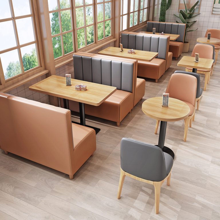 Modern restaurant interior featuring booth seating, wood tables, and warm natural lighting.