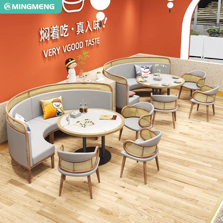 Curved dining booths with gray cushions and matching rattan chairs around round tables in a modern restaurant setting.