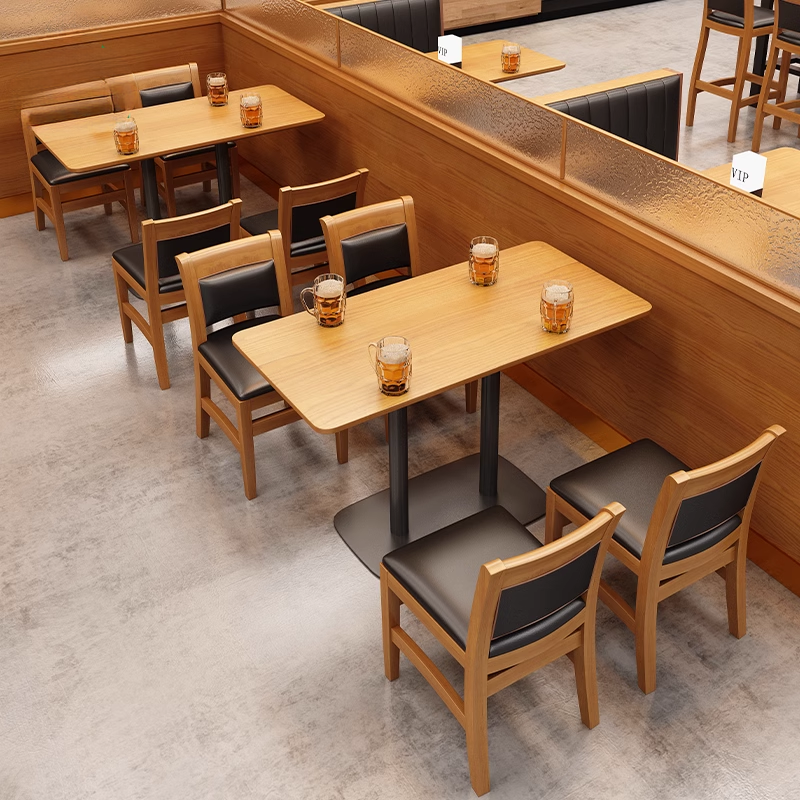 A restaurant seating area with wooden tables, booths, and chairs, featuring glasses of beer and a VIP sign.