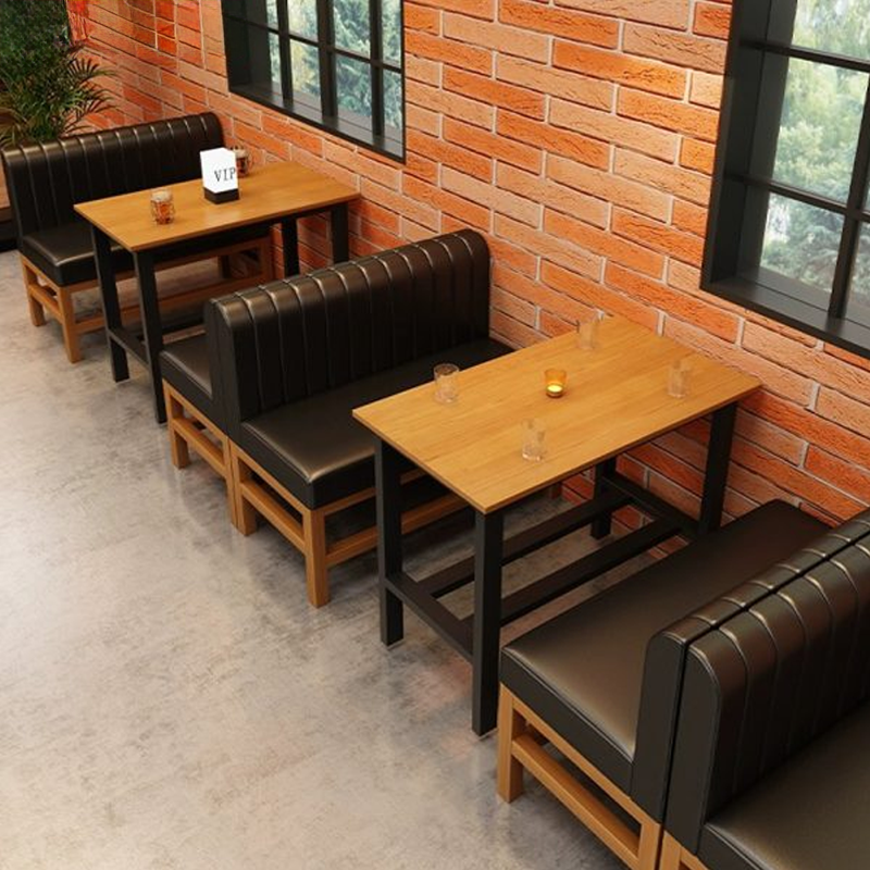 A spacious bar area with high bar stools, tables, and seating along brick walls.