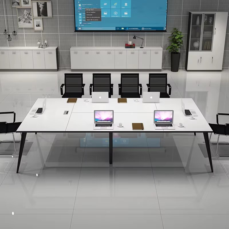 sleek meeting room table with black ergonomic chairs and tech-friendly design