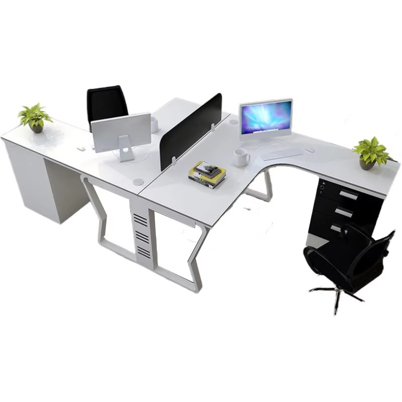 L - shaped office desk with computer, books, and potted plants, accompanied by an office chair and storage cabinets