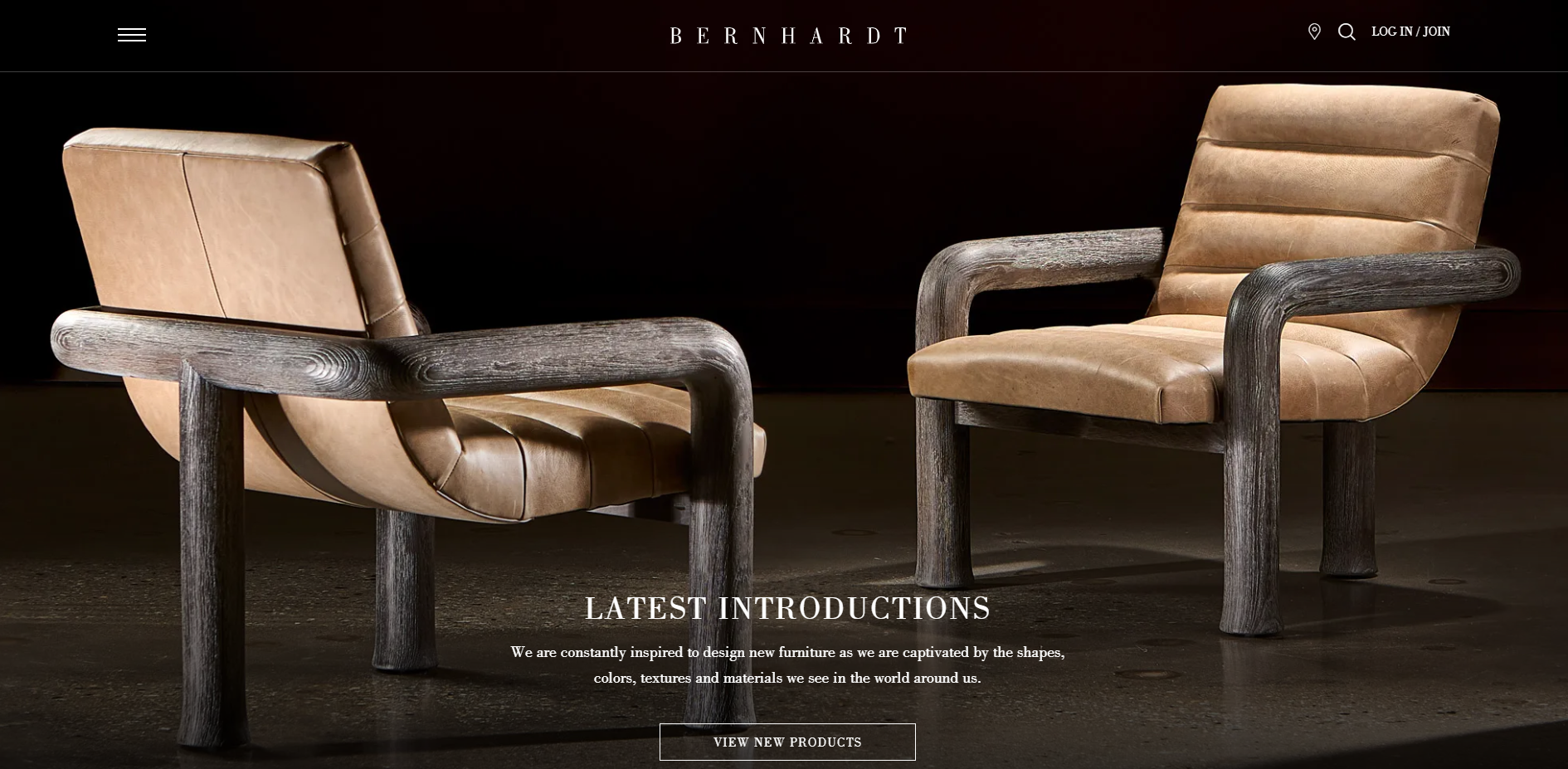 A pair of Bernhardt modern accent chairs featuring caramel leather upholstery and a sculptural, weathered wooden frame. 