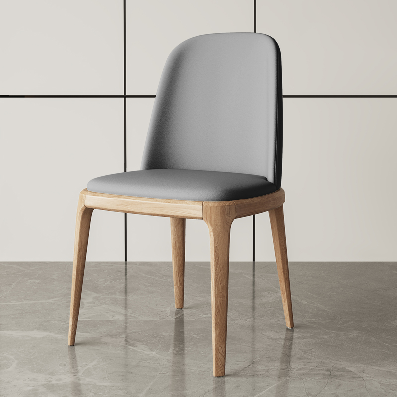 Contemporary gray leather dining chair with a modern wooden base, designed for both comfort and aesthetics.