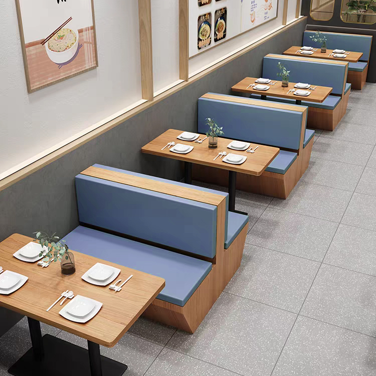 Modern restaurant booth seating area with wooden tables and blue padded seating, offering a cozy and practical dining experience.