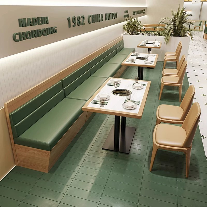 Green leather booth seating with wooden frames, featuring a modern design for upscale dining spaces.