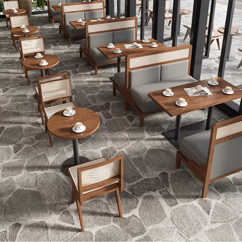 Top view of restaurant booth seating with gray padded cushions and rattan chairs paired with wooden tables, offering a cohesive dining experience.