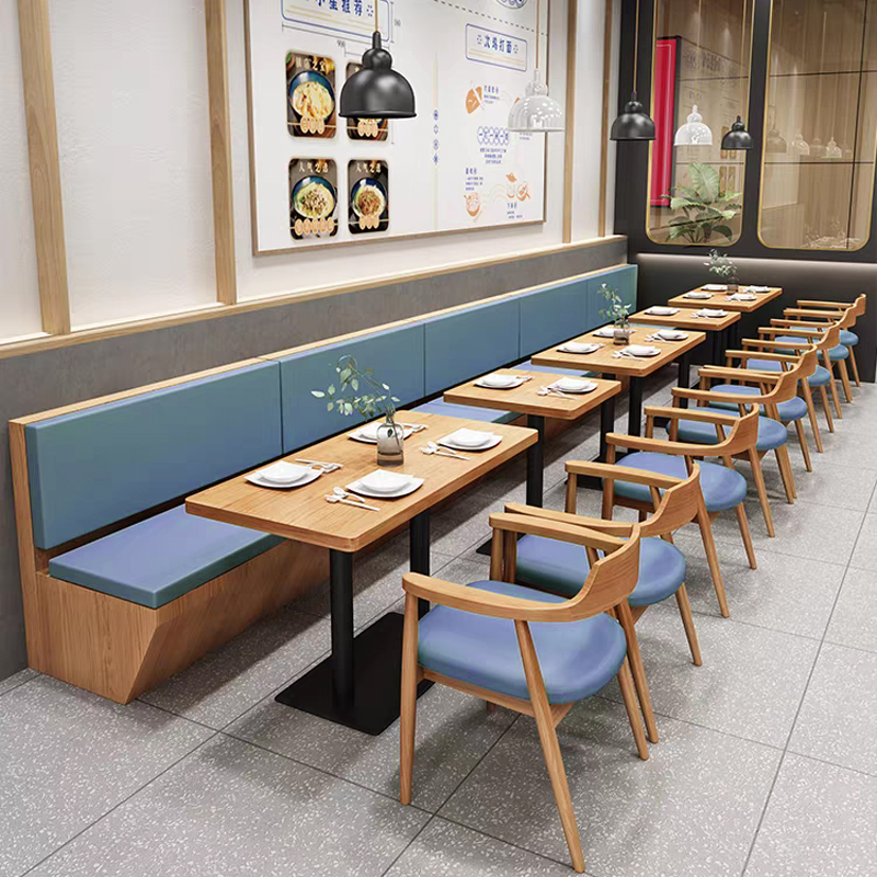 Restaurant seating booth with blue cushions and stylish multilayer wood veneer tables, offering comfort and elegance for dining spaces.