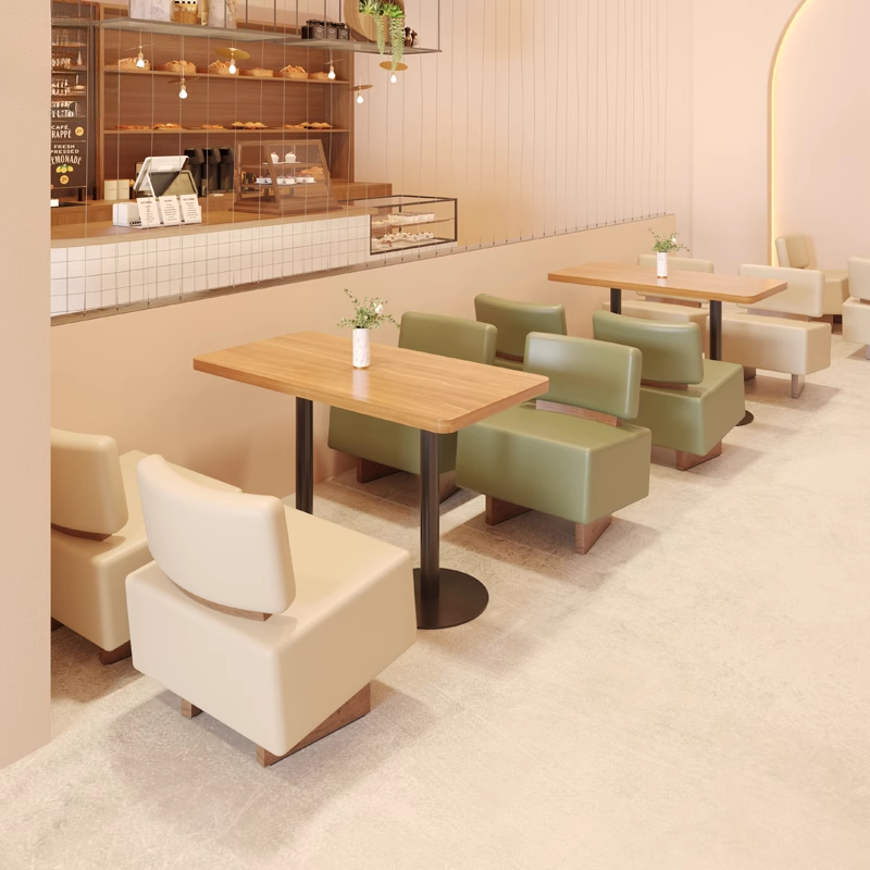 A well-organized cafe seating arrangement with wooden tables and green leather chairs, creating a warm and functional space.