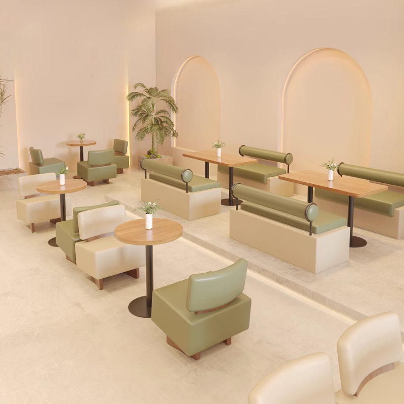 Booth seating arrangement with green and beige cushions in a modern café lounge.