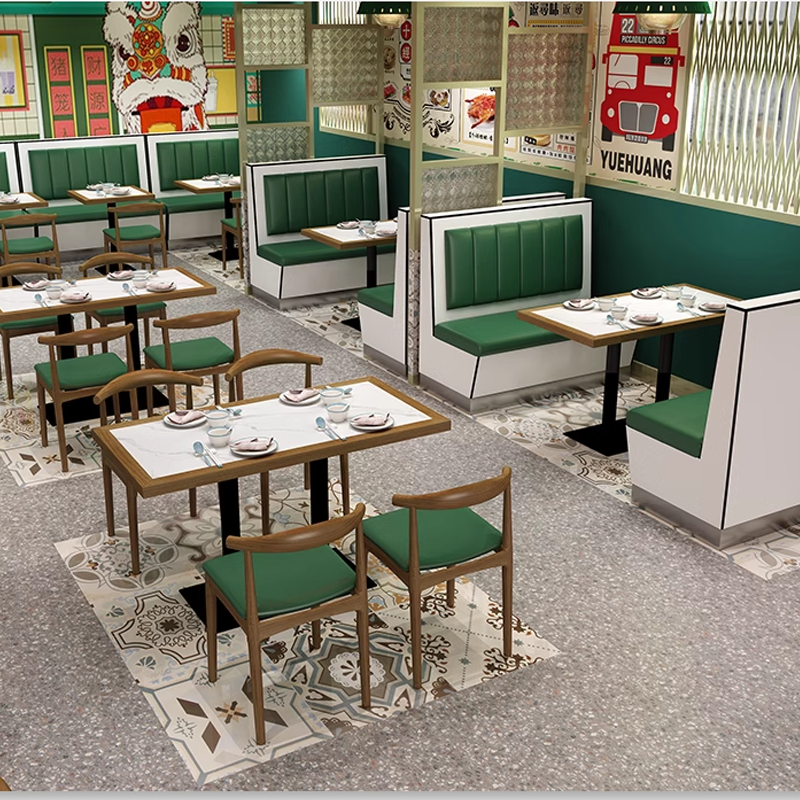 Cozy restaurant interior with green booth seating, wooden tables, and eclectic decor, creating a relaxed and inviting dining space.