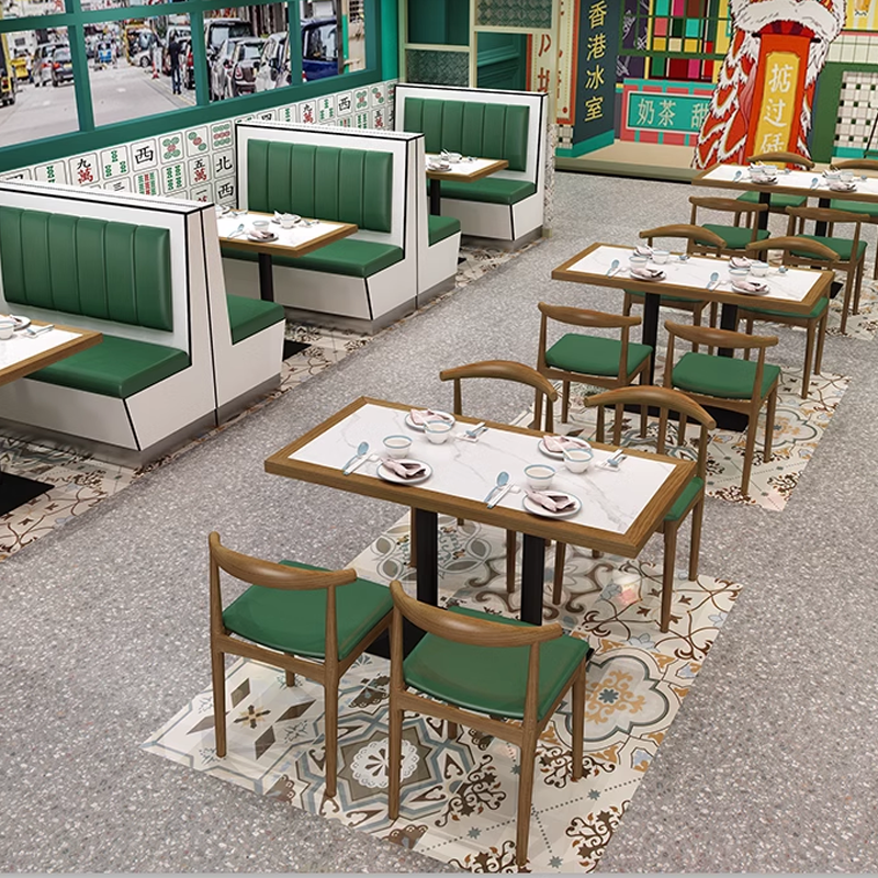 Dining area with green booth seating, wooden tables, and wooden chairs, offering a modern and stylish restaurant atmosphere.