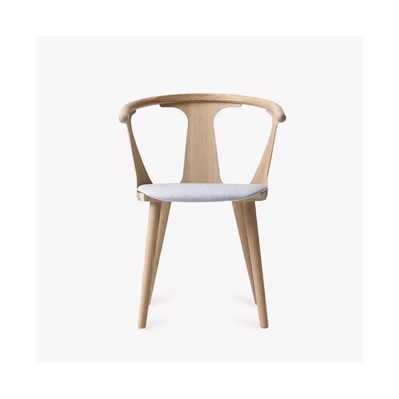 Light wooden armchair with a light gray cushioned seat, featuring a curved backrest and minimalist design.