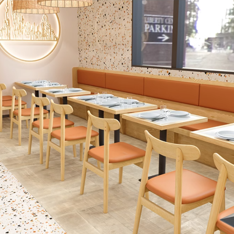 Linear dining layout with light wooden chairs and booths featuring orange cushions, modern restaurant design with elegant table settings.