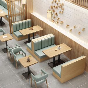 Mint green booth seating and armchairs paired with wooden tables in a sophisticated cafe layout.