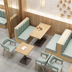 Mint green booth seating paired with wooden tables and matching armchairs in a modern cafe setting.