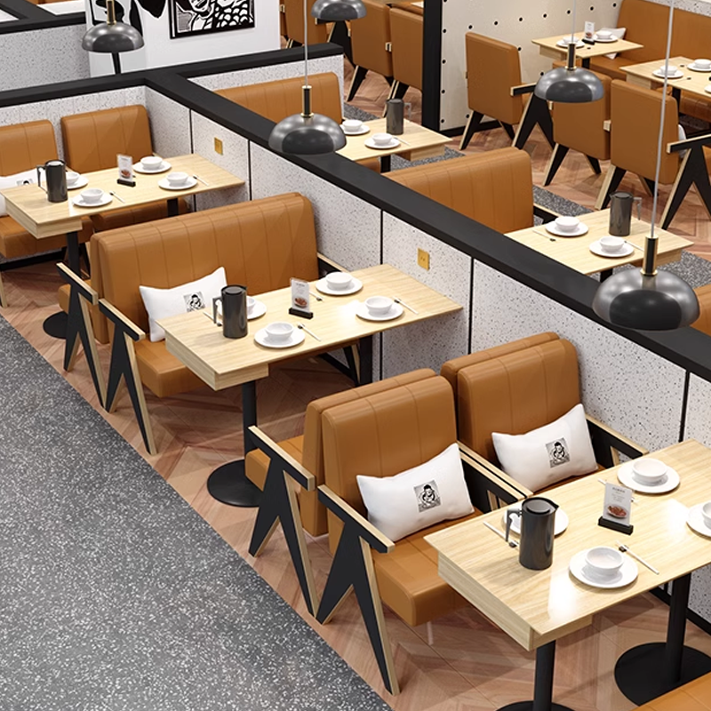 Modern booth seating with brown leather chairs, paired with rectangular wooden tables, set in a contemporary restaurant layout featuring decorative lighting and clean partitions.