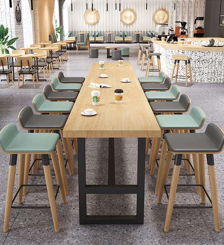  Modern cafe seating layout featuring green cushioned benches, gray chairs, round wooden tables, and bar seating for a versatile dining experience.