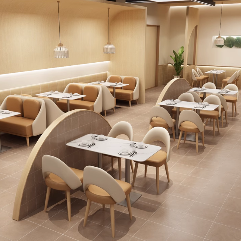 Open dining layout with curved partitions, white marble-top tables, and cushioned chairs.