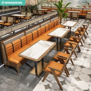 Modern restaurant furniture layout featuring orange cushioned benches, wooden chairs, marble-top tables, and cane details, creating a vibrant dining space.