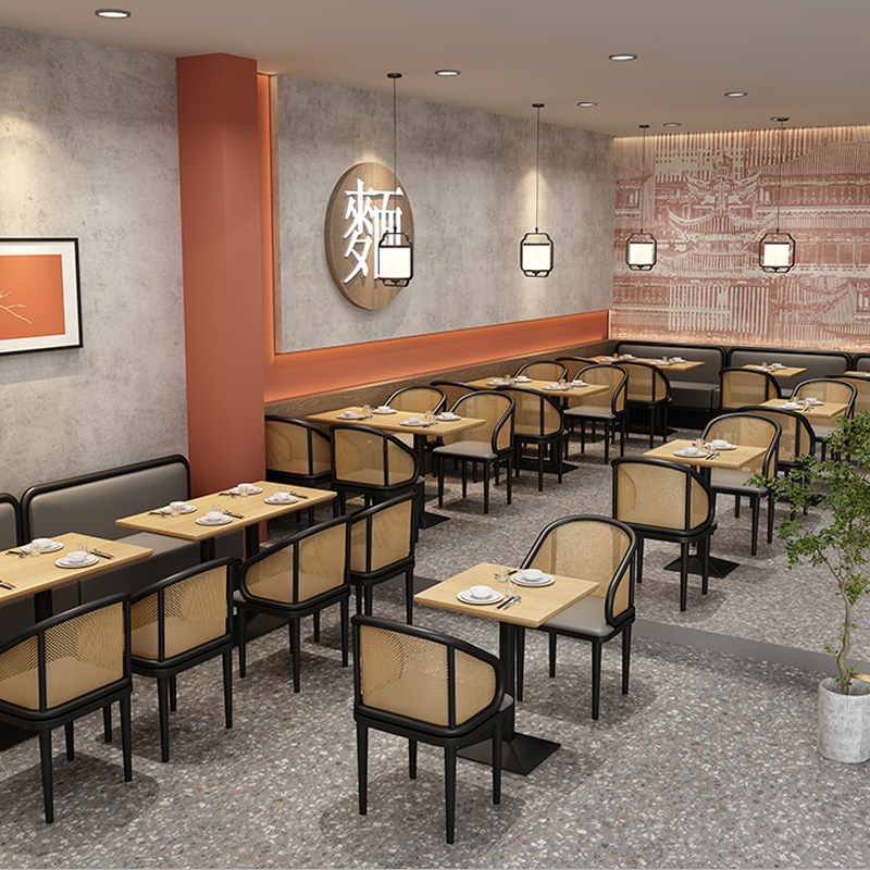 Modern restaurant interior with mesh chairs, wooden tables, pendant lighting, and a decorative wall, perfect for dining spaces and eateries.