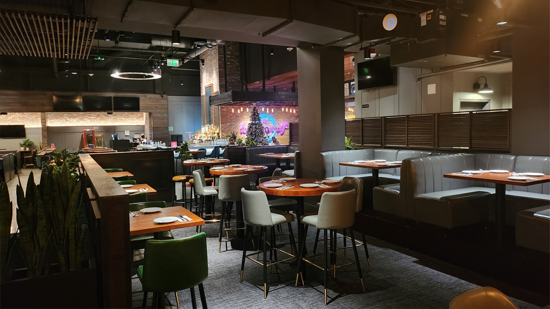 Modern restaurant interior with dining tables and bar area, cozy ambiance, seating arrangements, and neon decoration