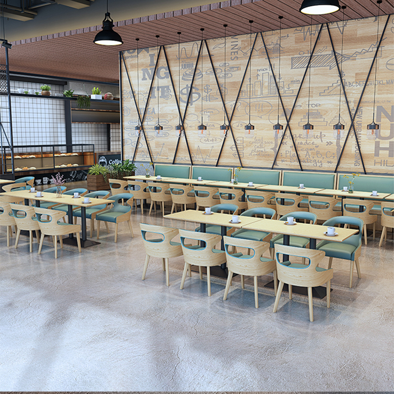 Modern Restaurant Seating with Green Cushions, Wooden Tables, and Industrial Wall Decor