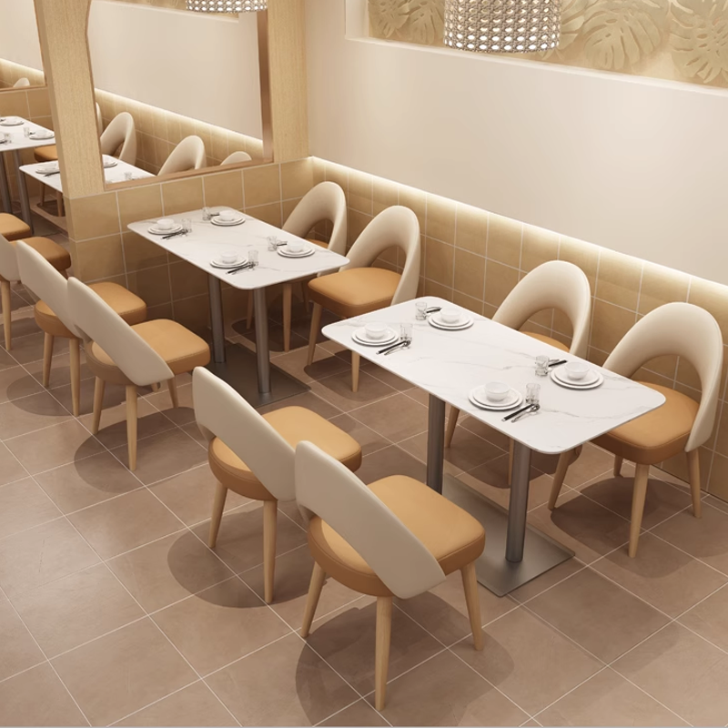 Modern restaurant table and chair set with cream and brown seating, marble top, perfect for cafes, bistros, or dining rooms.