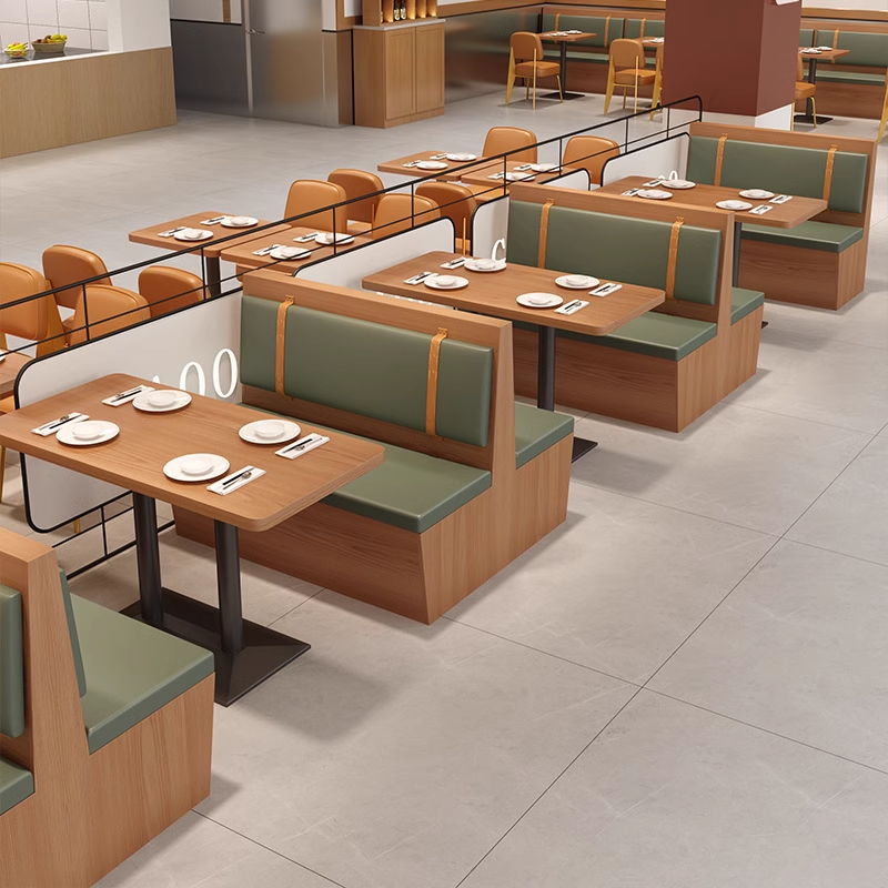 Parallel booth seating with green cushions and rectangular wooden tables in a modern dining space.