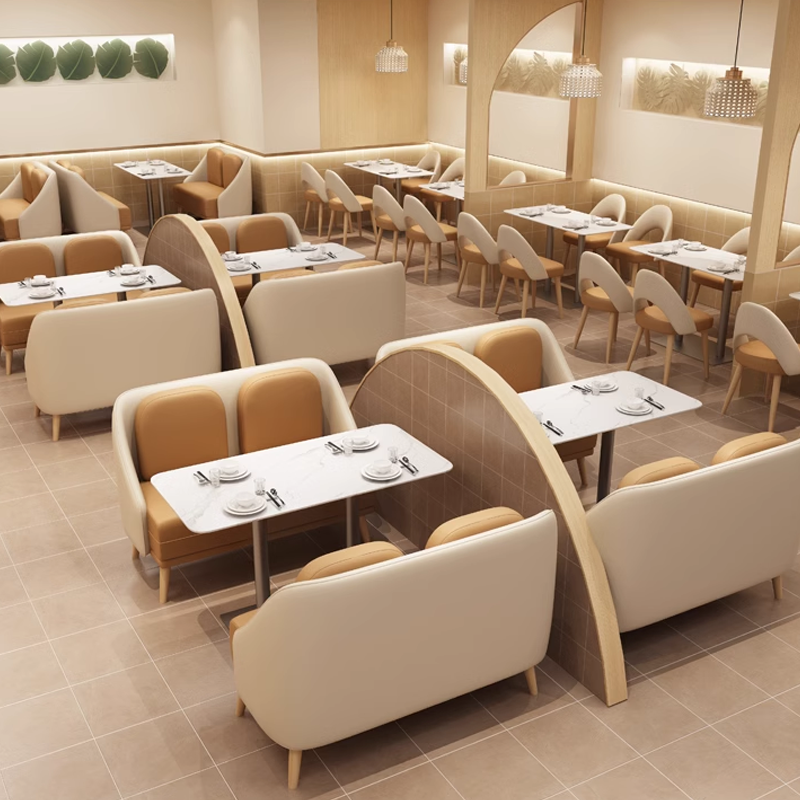 Open dining layout with curved partitions, white marble-top tables, and cushioned chairs.