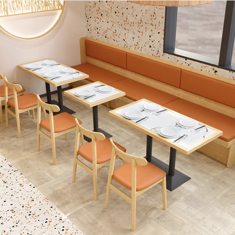 Linear dining layout with light wooden chairs and booths featuring orange cushions, modern restaurant design with elegant table settings.