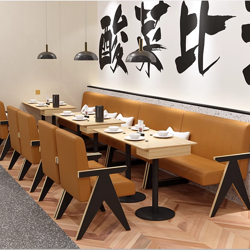 Restaurant furniture set with brown leather chairs, wooden tables, and pendant lighting, arranged along a wall with bold decorative lettering for a modern dining experience.