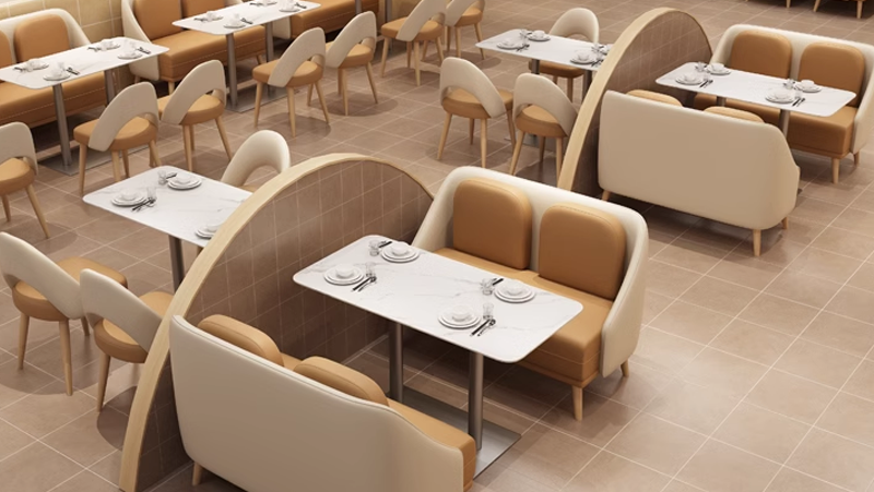 Modern restaurant booth seating with arched dividers, beige and brown upholstered seating, and marble tables. Suitable for casual dining.