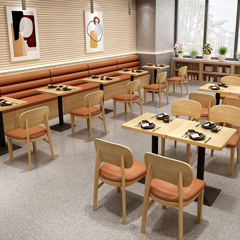 Modern restaurant interior with booth seating and wooden chairs featuring cushioned seats