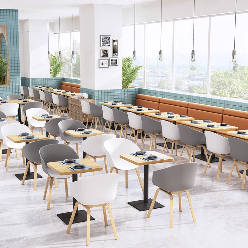 Restaurant seating with a mix of booth seating and shell chairs, featuring wood tables and a bright, contemporary layout