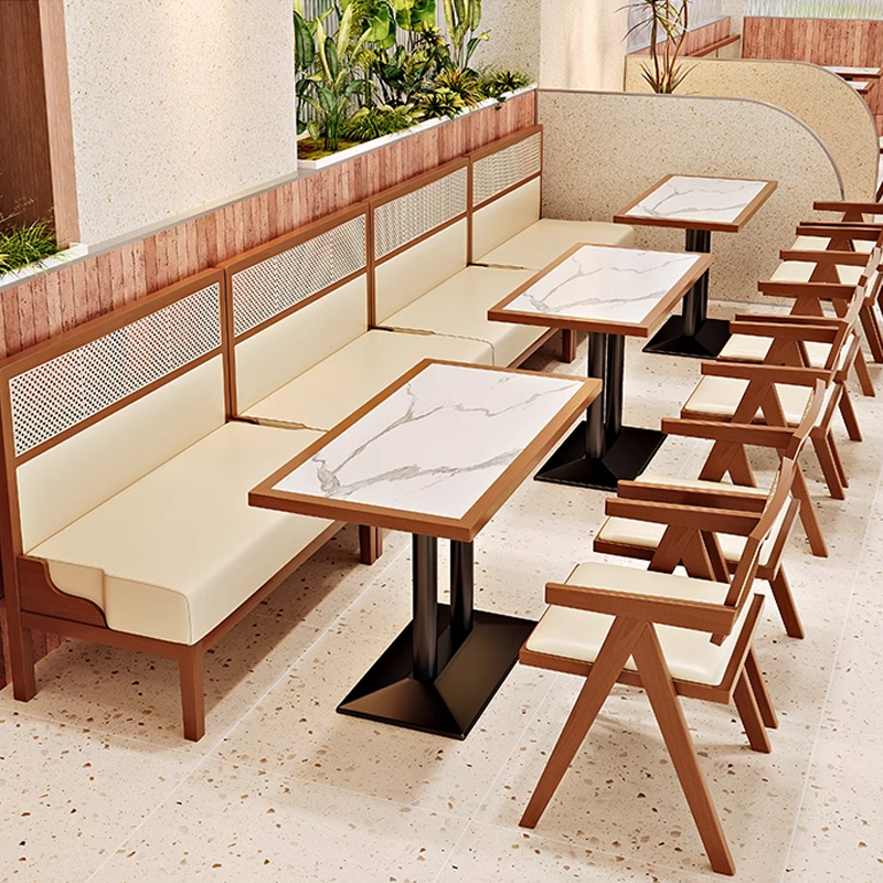 Modern restaurant seating featuring cane-back chairs and marble-topped tables, ideal for contemporary dining spaces.