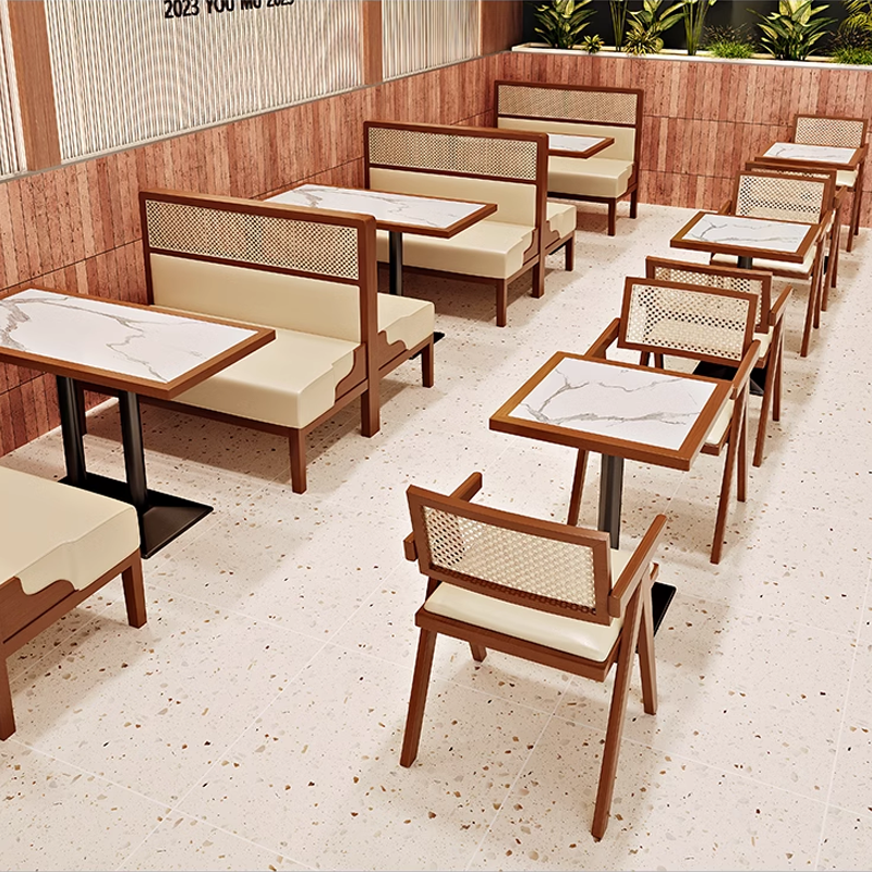 Elegant cane-back chairs and marble tables arranged in a chic dining room, ideal for modern interior design.