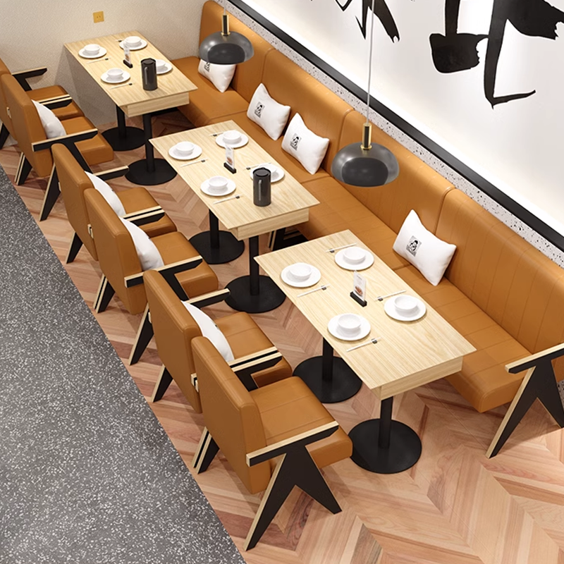 Contemporary restaurant booth seating layout featuring brown leather chairs, wooden tables with black bases, pendant lighting, and modern partition designs for a stylish dining environment.