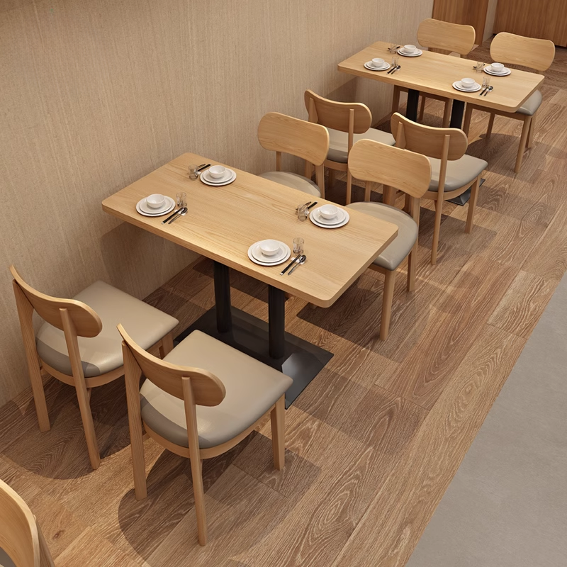 Restaurant seating arrangement featuring wooden chairs with beige cushions and tables, perfect for modern dining environments.