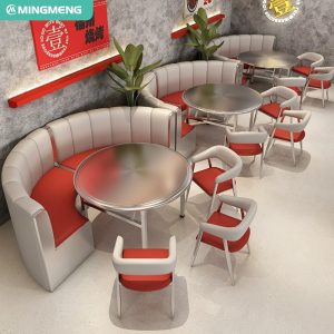 Retro-style round booth seating with red and white upholstery, complemented by metallic chairs and circular tables.