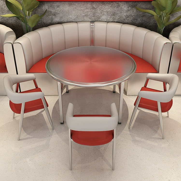 Round dining table with red and white curved booth seating and matching chairs.