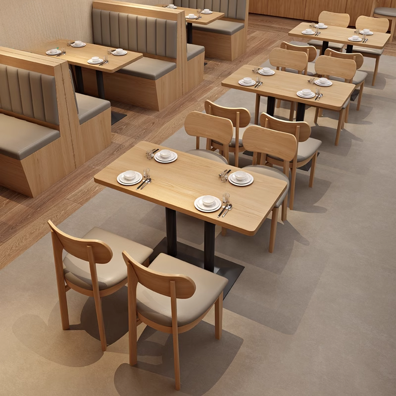 dining tables and light wooden chairs with beige cushioned seating at a modern restaurant.