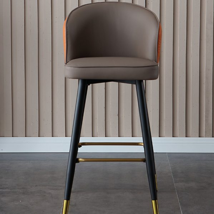 Stylish bar chair with an orange leather backrest, black and gold frame, ergonomic design for comfort and elegance.